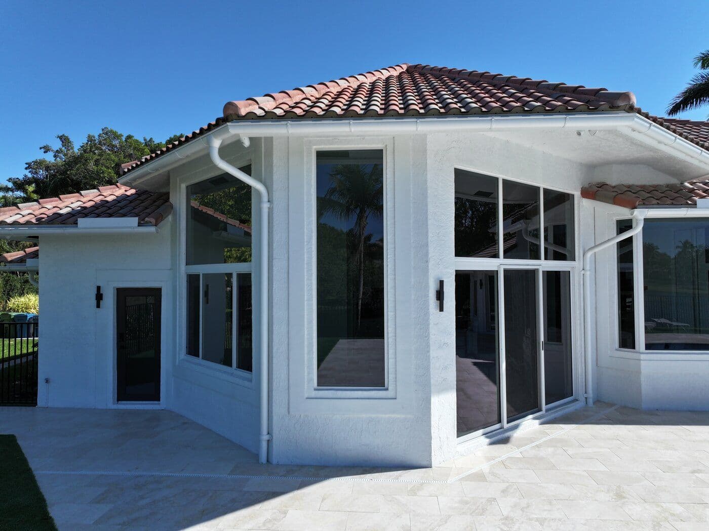 Waterfront South Florida home with full-height impact sliding doors framing a sunset view